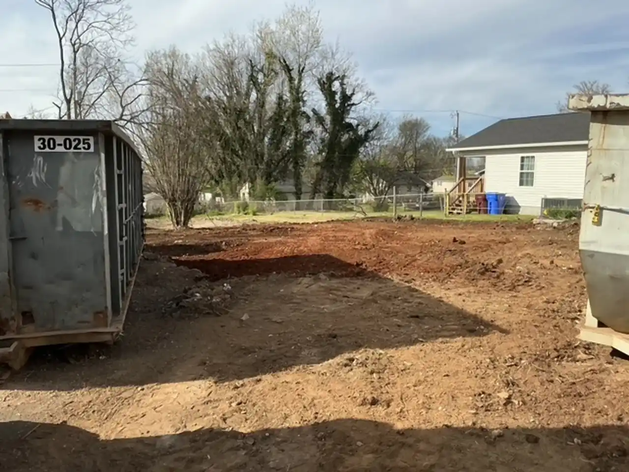 Roll-off dumpster beside a freshly graded lot after demolition debris removal, R&G Land Clearing