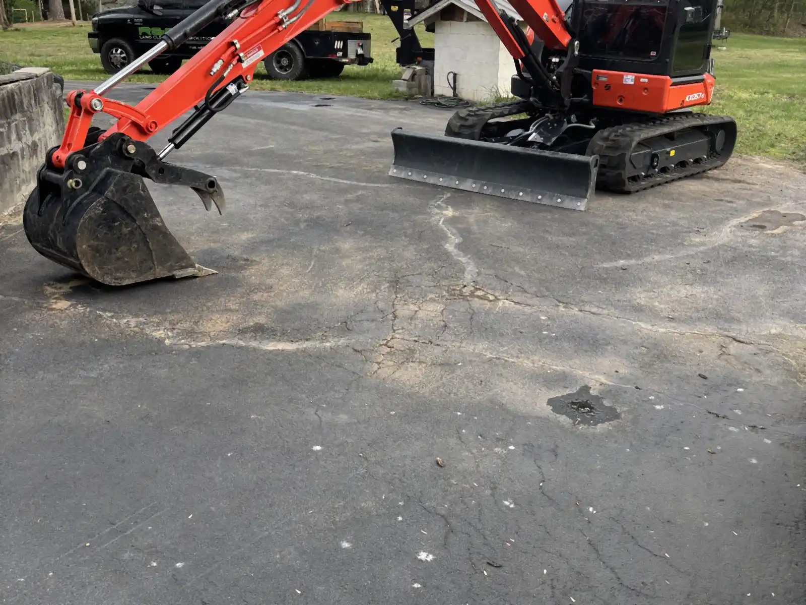 R&G Land Clearing's Kubota excavator staged on a driveway
