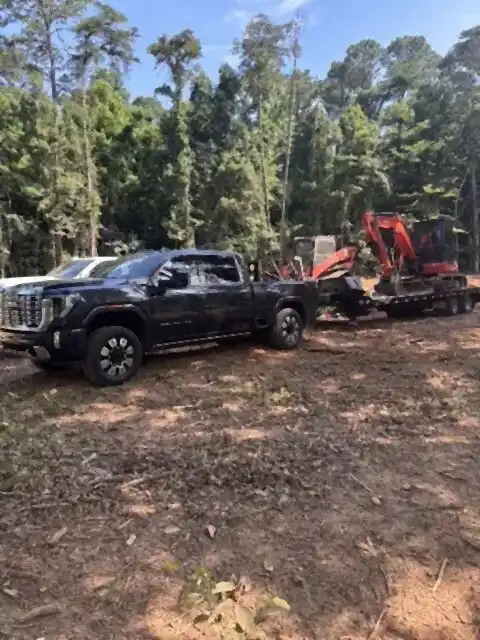 Trucks and excavator on a freshly cleared lot