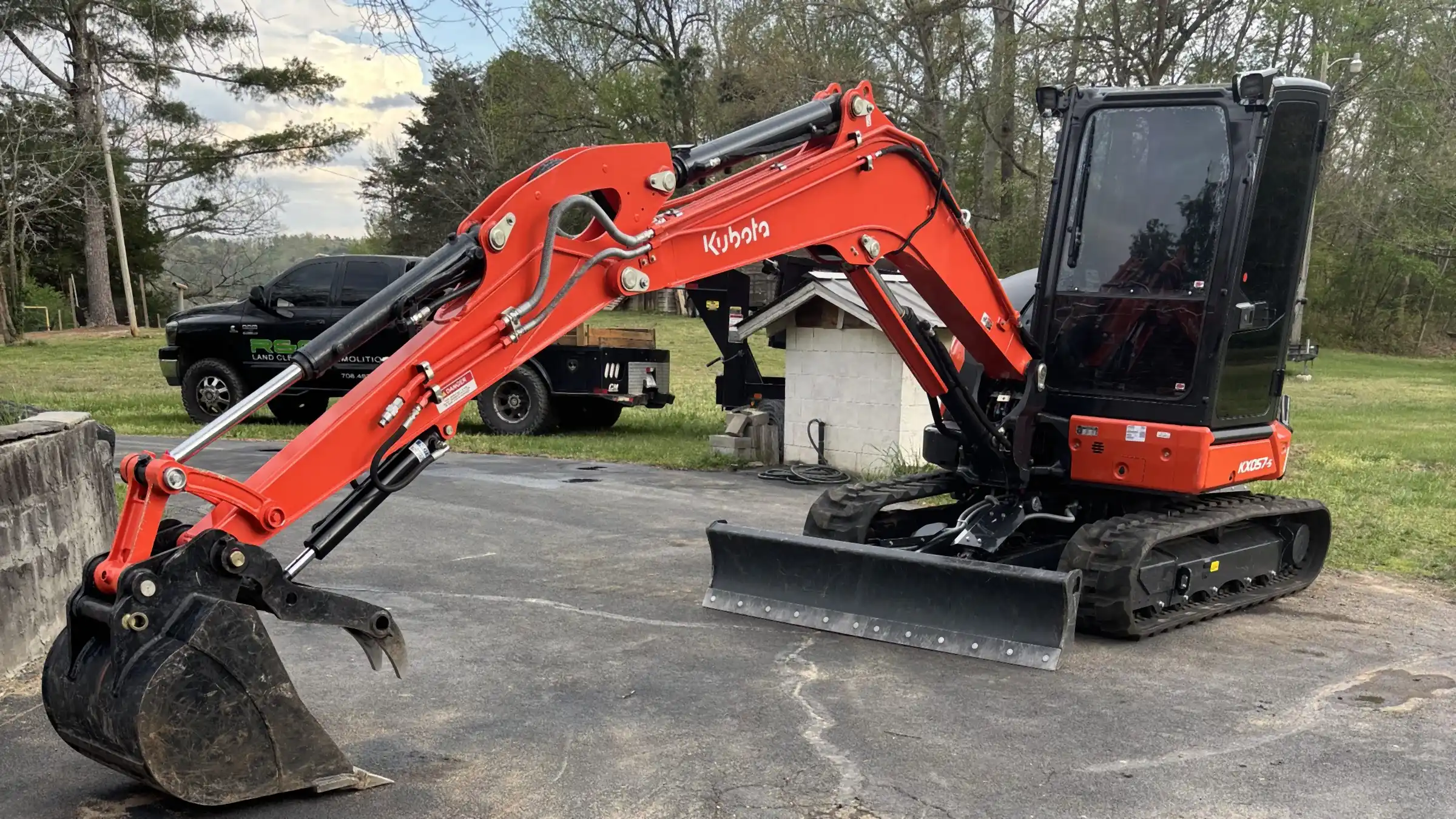 R&G Land Clearing's orange Kubota excavator staged on a driveway before a demolition job