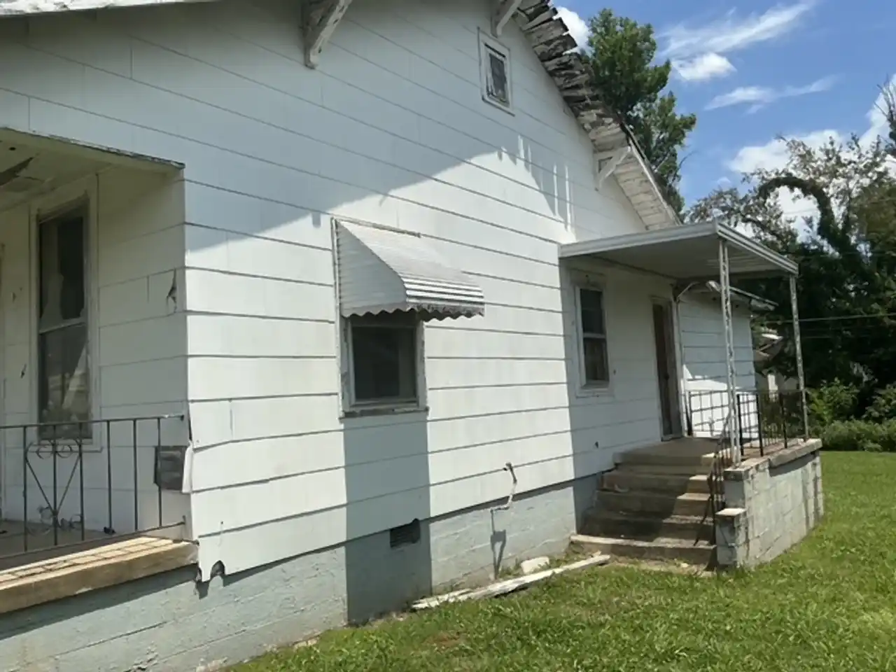 Vacant white house with a front porch before demolition, R&G Land Clearing