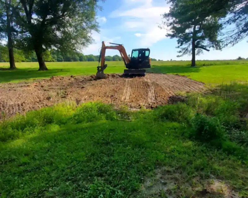 Excavator leveling a cleared field