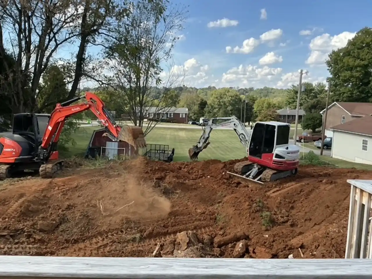 Excavators backfilling a pool fill-in, seen from the back deck, R&G Land Clearing
