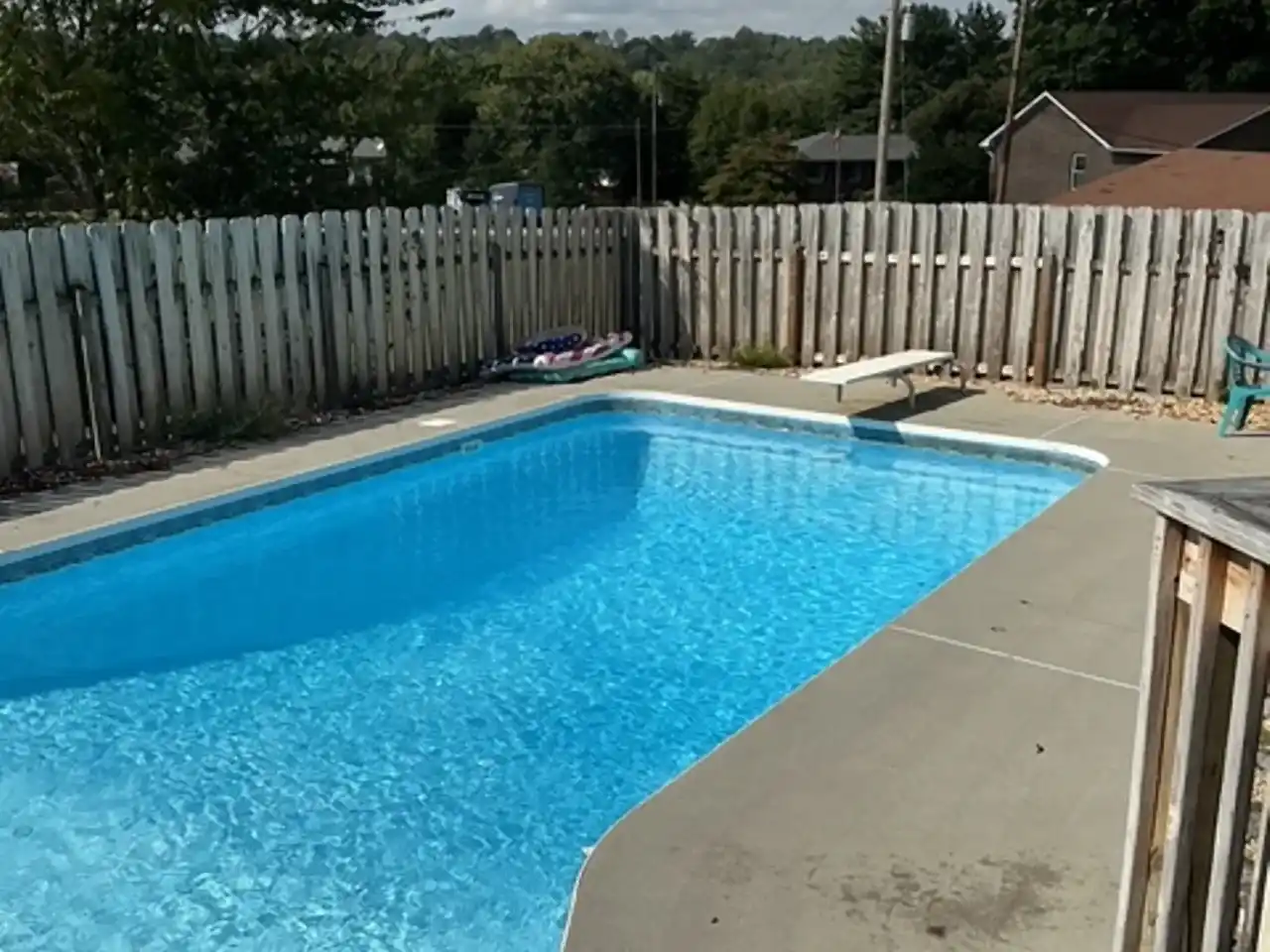 In-ground pool with diving board and concrete deck before removal, R&G Land Clearing