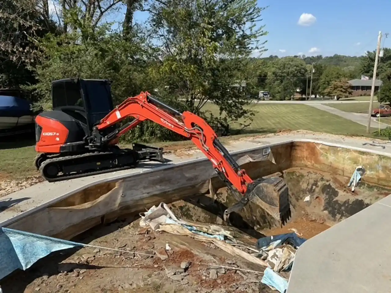 Excavator digging out the liner and walls of an in-ground pool, R&G Land Clearing